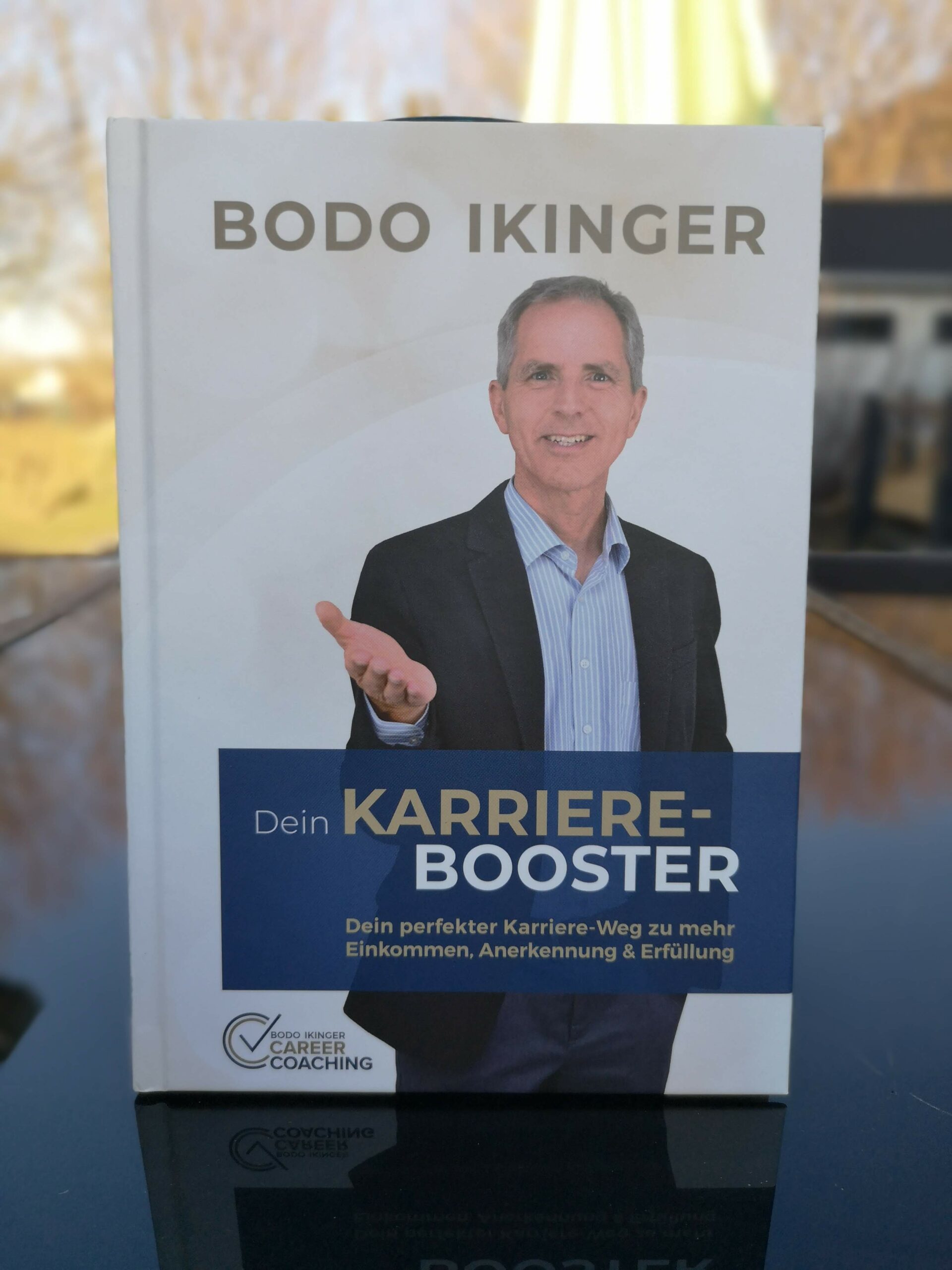 Dein Karriere Booster als stehendes Buch auf einer Tischplatte