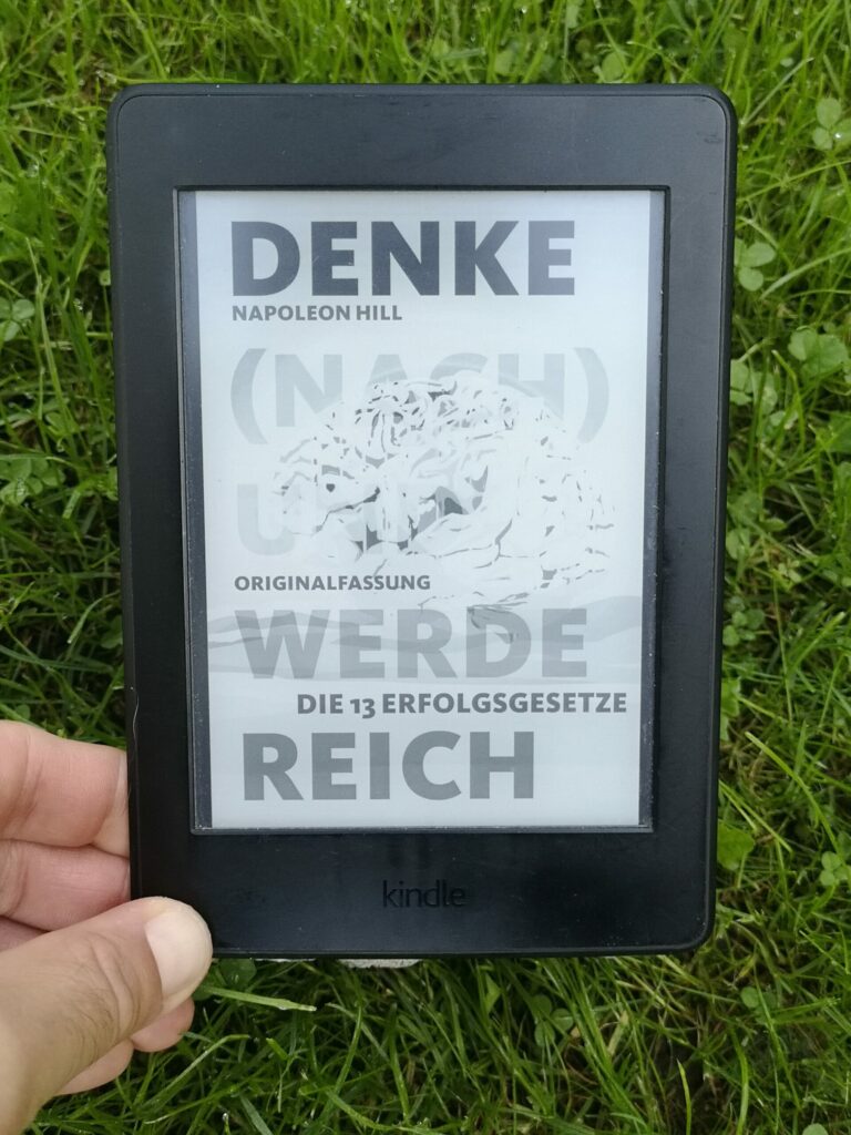 Das Buch Denke nach und werde reich liegt auf dem Rasen